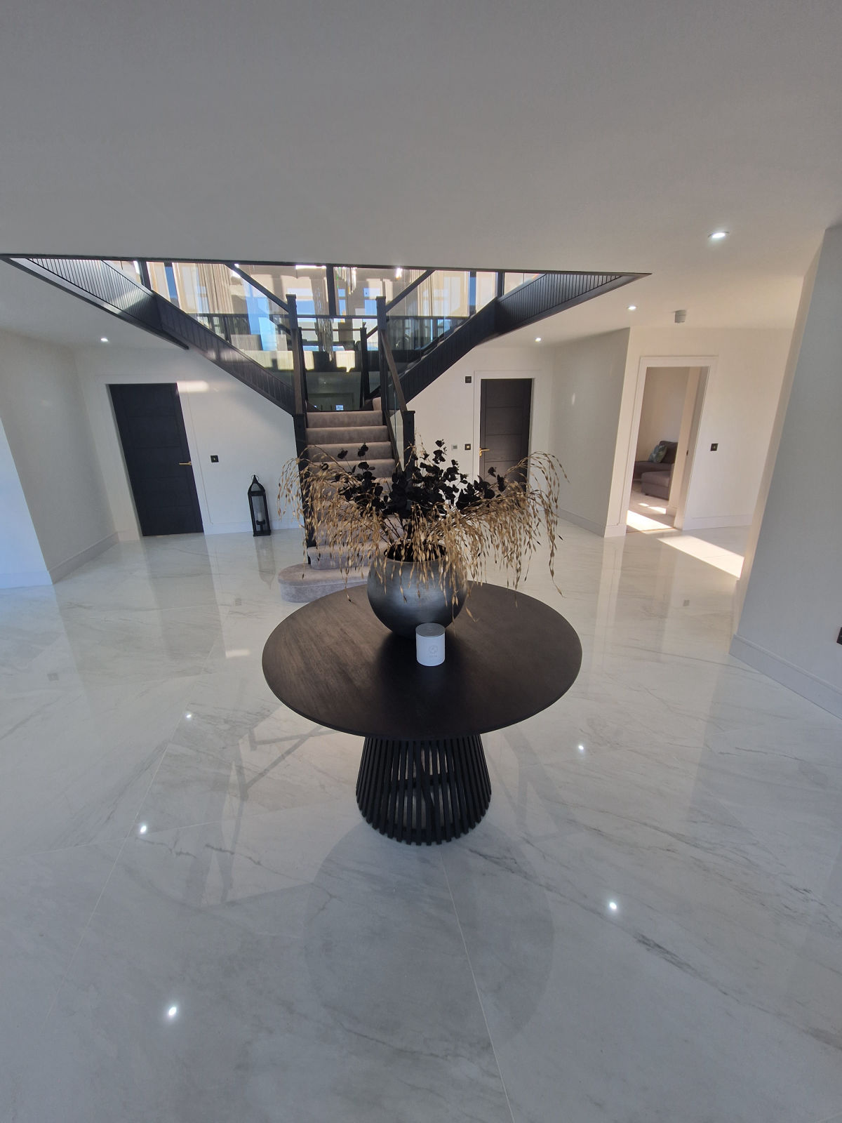 A polished marble-effect porcelain floor running through a large open hallway